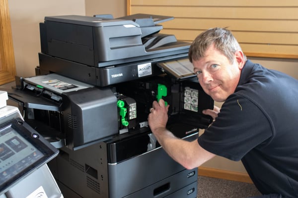 A copier repair technician servicing a Toshiba copier.