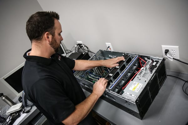 A managed services technician setting up IT hardware.