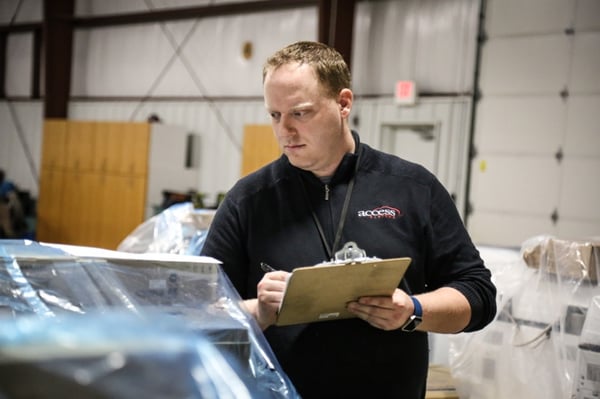 A man checking copiers into the warehouse inventory at Access Systems.