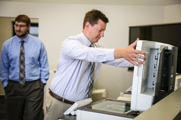 A managed print professional examining a copier