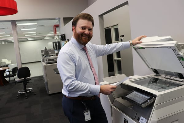 A man scanning a document into the copier machine