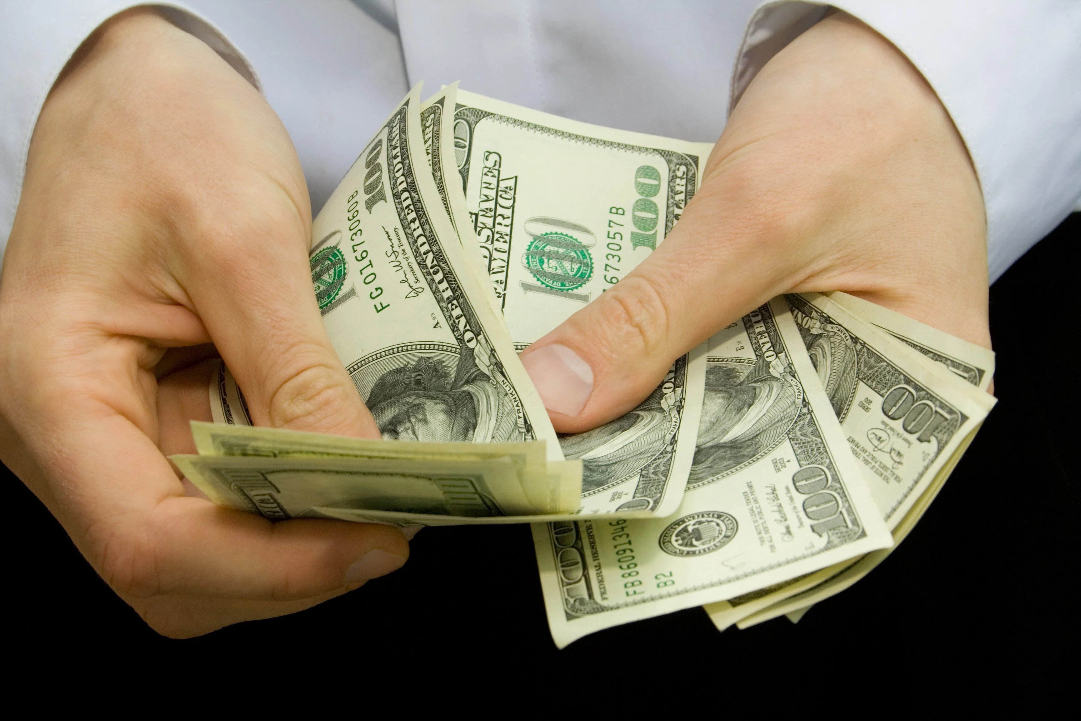 man_counting_hundred-dollar_bills_GettyImages-8.original
