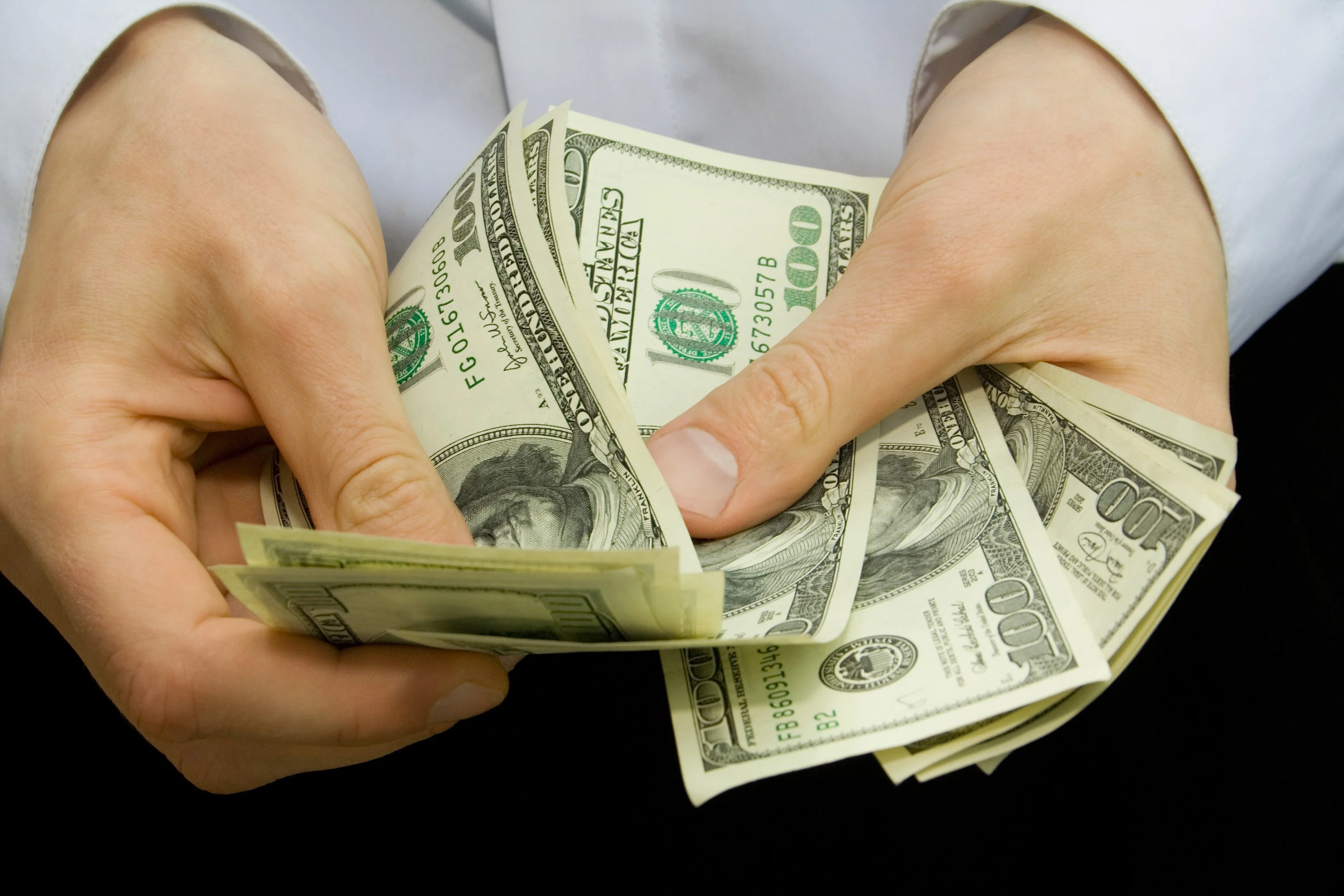 man_counting_hundred-dollar_bills_GettyImages-8.original